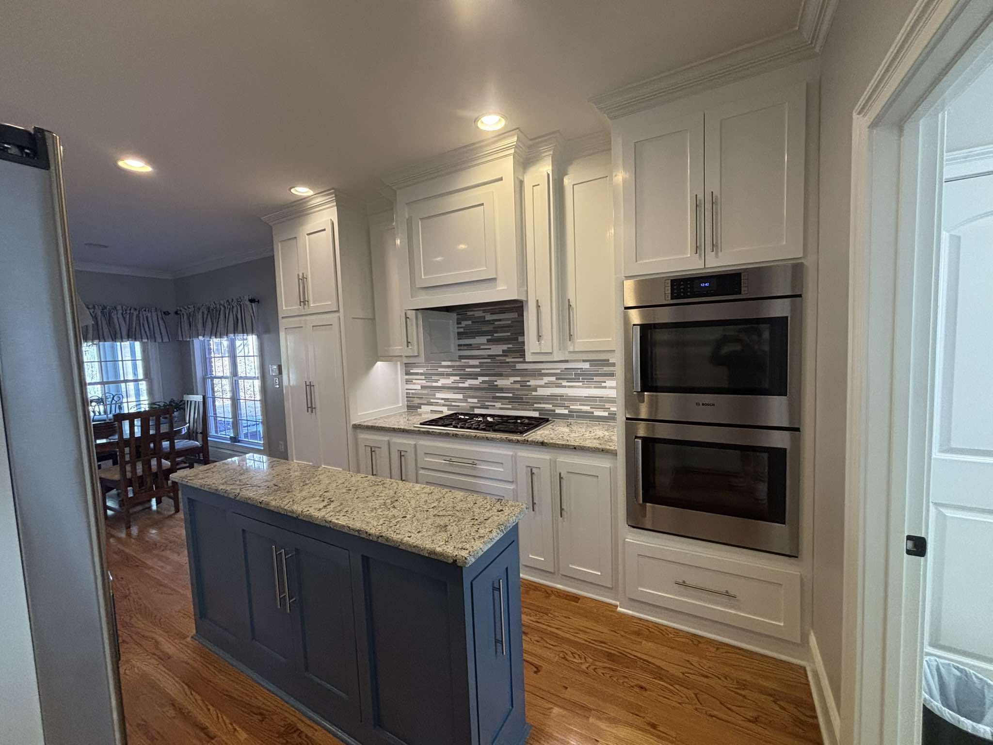 Finished kitchen with freshly painted white cabinets and a dark island