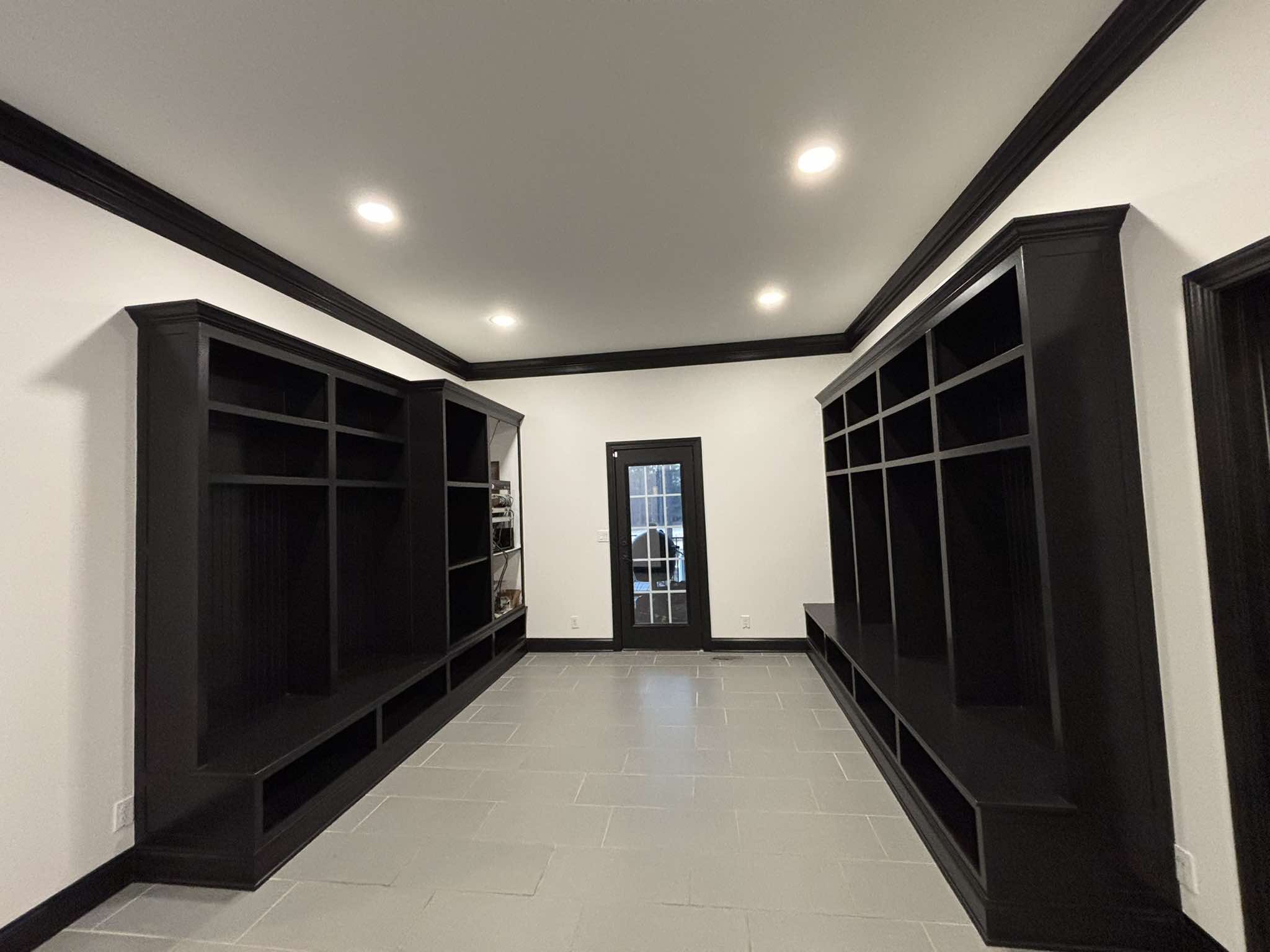 Finished black built-in storage, doors, and trim in a bright interior