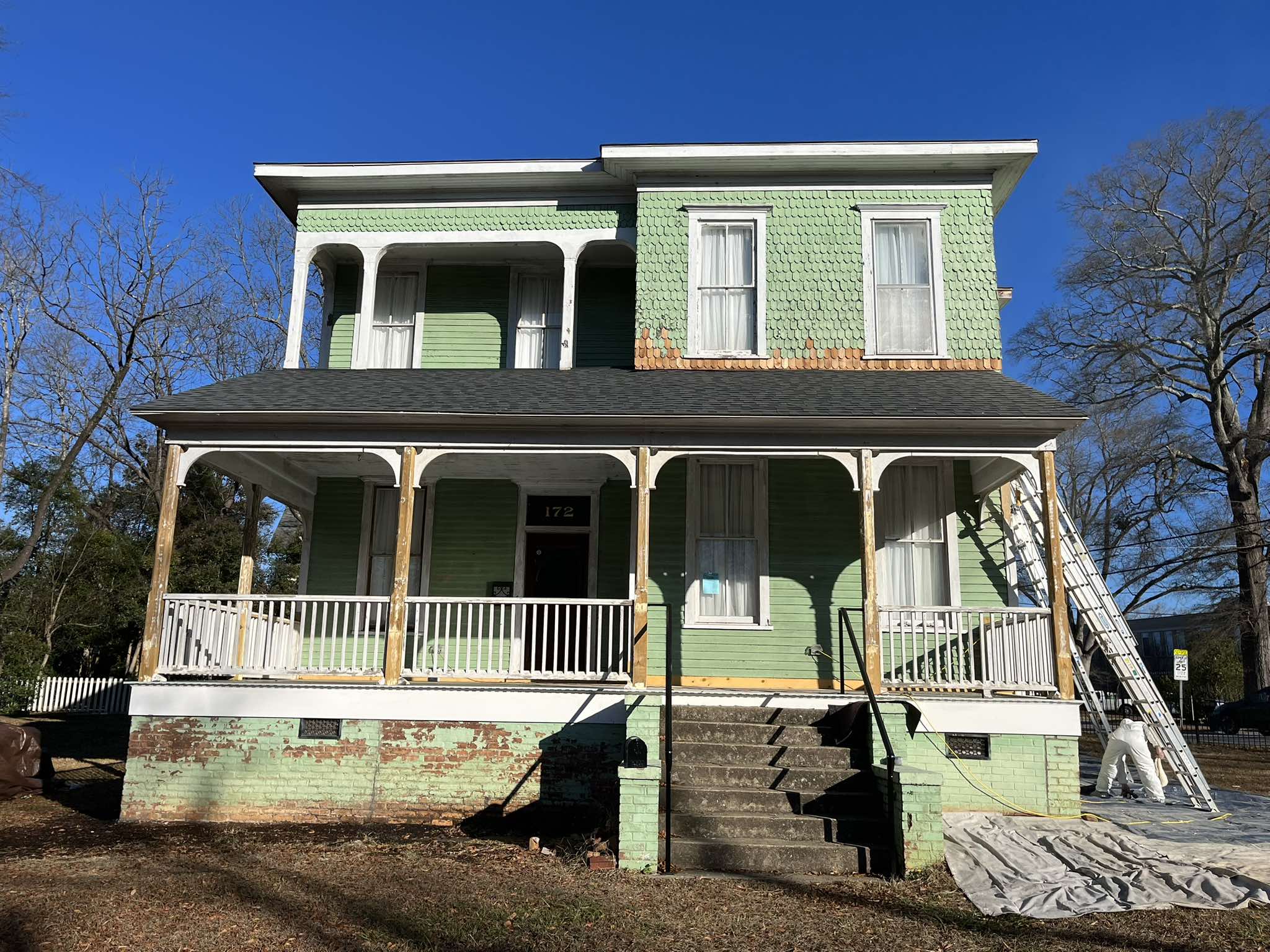 Green exterior of a historic home before its blue-gray repaint